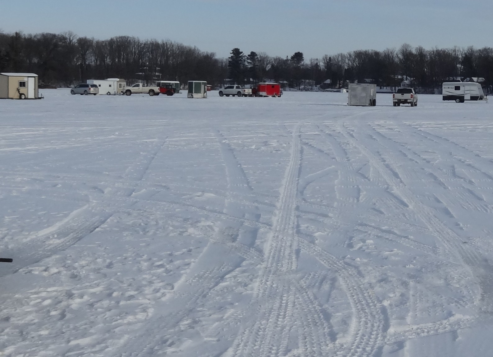 Small group of cars, pick-up trucks and ice shanties on the ice