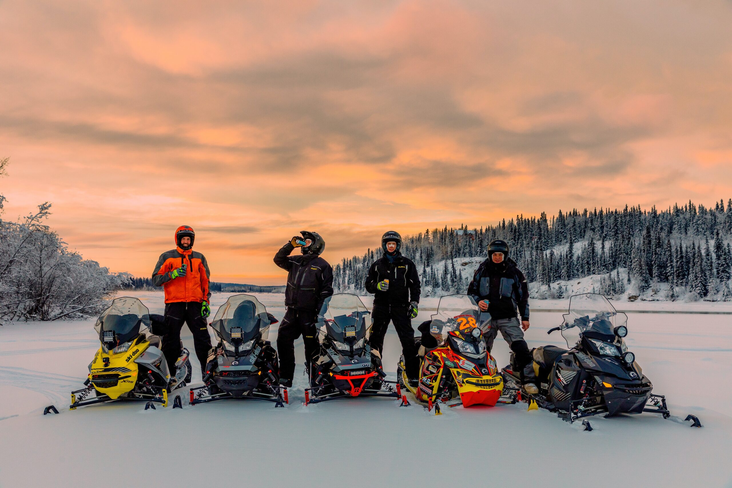 snowmobilers at sunset